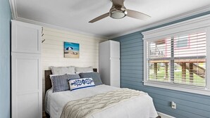 A bedroom with a bed, a ceiling fan, a window with blinds, and a painting on the wall. - SAN LUIS BEACH GEM - Bay & Gulf Views, Boat launch access, Short Walk to Beach (Freeport)