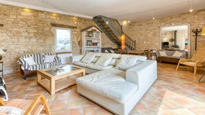 A spacious living area with a stone wall, a wooden staircase, and a fireplace. - Gorgeous home in Saint-Pierre-d'Oléron with WiFi (Saint-Pierre-d'Oléron)