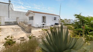 A white house with a tiled roof, a small patio with a table and chairs, and a large cactus in the foreground. - Pet friendly home in Saint-Pierre-d'Oléron (Saint-Pierre-d'Oléron)
