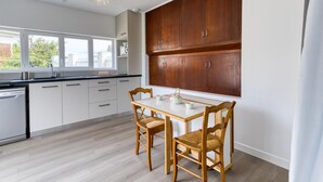 A modern kitchen with white cabinets, a wooden dining table, and a large window. - Pet friendly home in Saint-Pierre-d'Oléron (Saint-Pierre-d'Oléron)