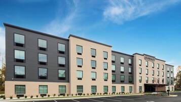 A multi-story hotel with a modern design, featuring a mix of window styles and a flat roof.