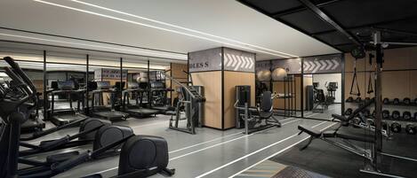 Ein modernes Fitnessstudio mit Laufbändern, Krafttrainingsgeräten und Kurzhanteln.