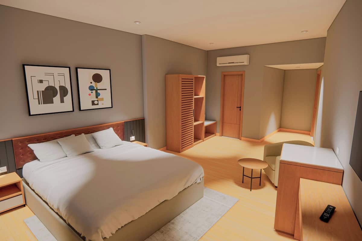 A modern bedroom with a large bed, a desk, and a chair. There are two framed artworks on the wall, a wardrobe, and an air conditioning unit.