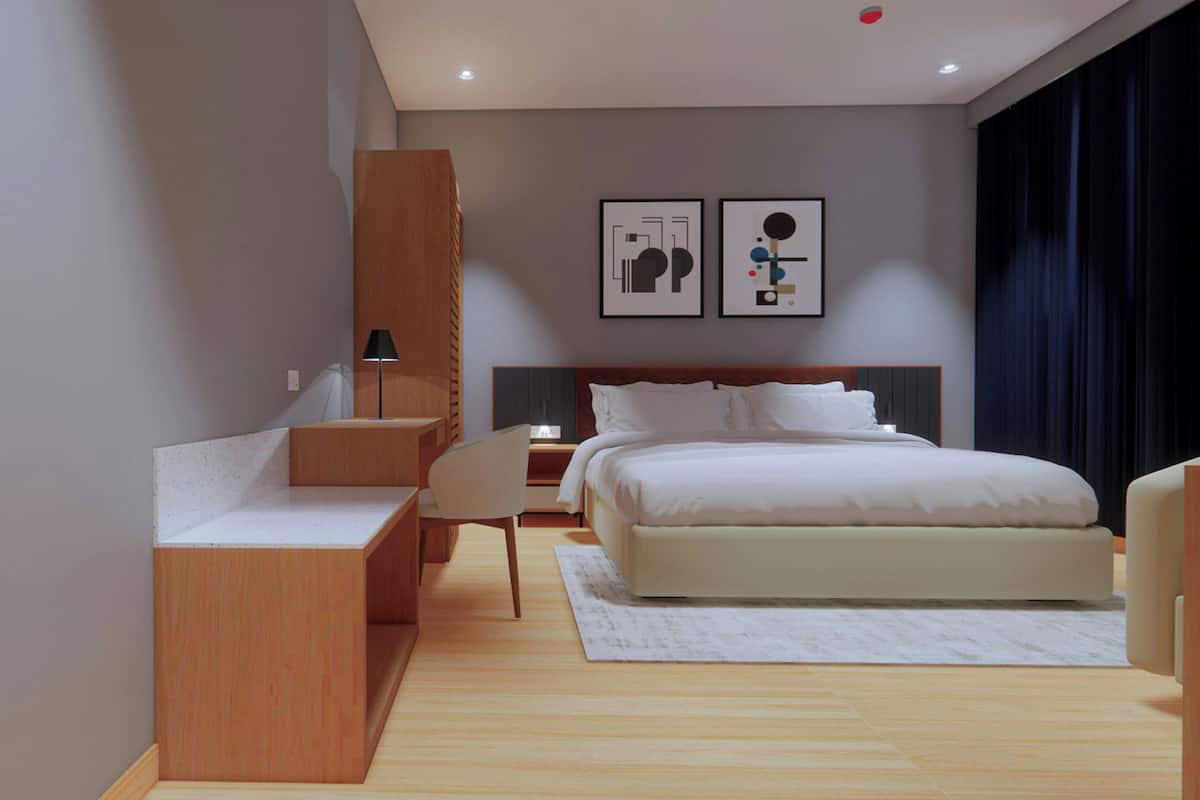 A modern hotel room with a large bed, a wooden desk, a chair, a nightstand, and two framed artworks on the wall.