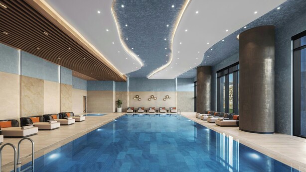 Una piscina interior moderna con zonas de estar y un diseño de techo contemporáneo.