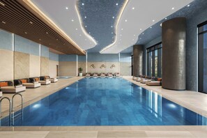 A modern indoor swimming pool with seating areas and a contemporary ceiling design. - Marriott Executive Apartments Istanbul Tema World (Istanbul)