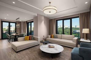A modern living room with a sofa, armchairs, a coffee table, and a dining area. - Marriott Executive Apartments Istanbul Tema World (Istanbul)
