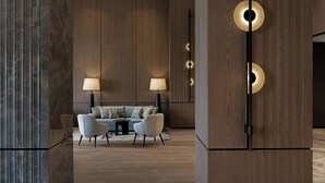 Una sala moderna con un conjunto de sofá, dos lámparas y una pared de acento de madera.