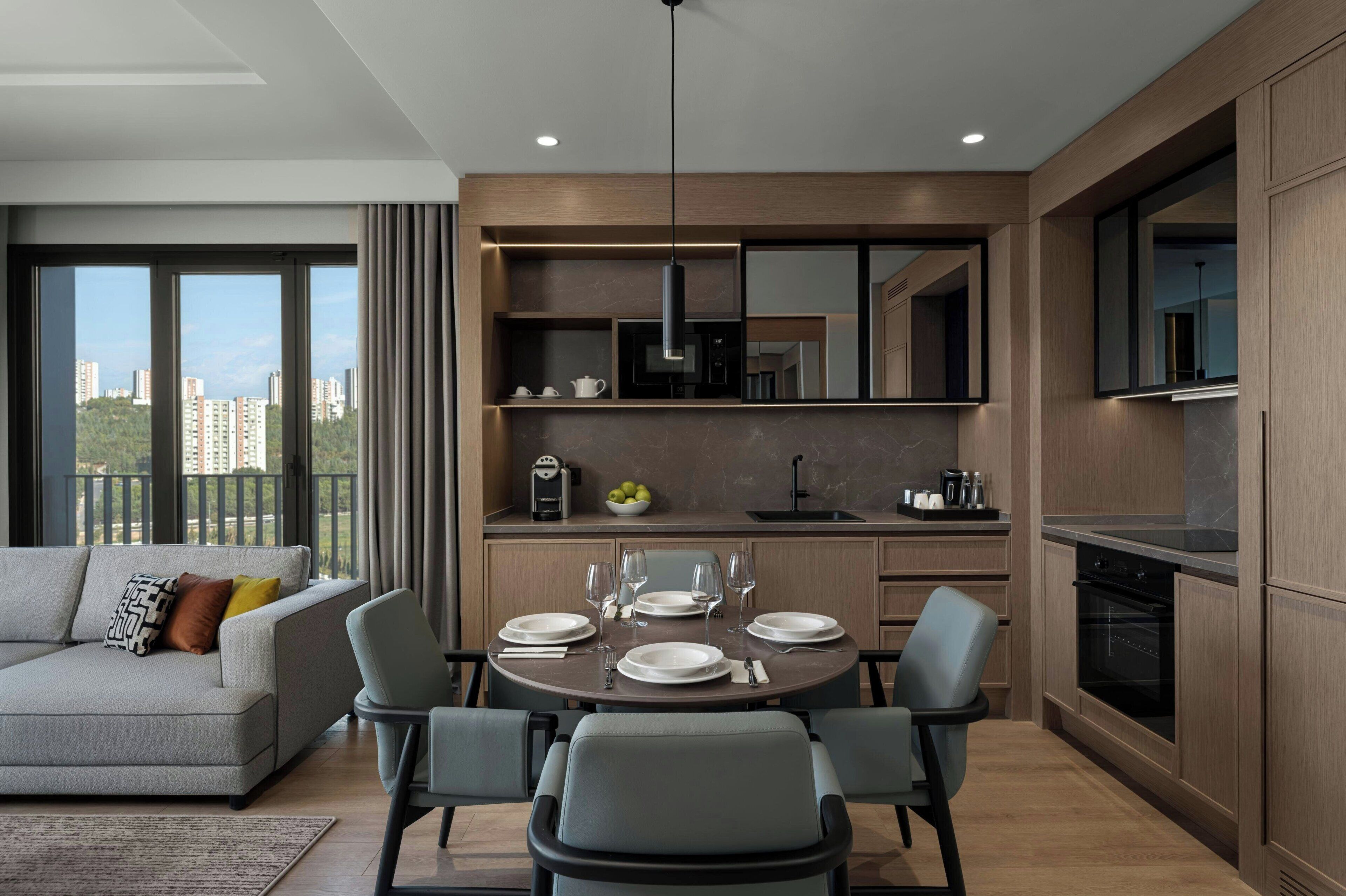A modern apartment with a dining area, kitchen, and living room.