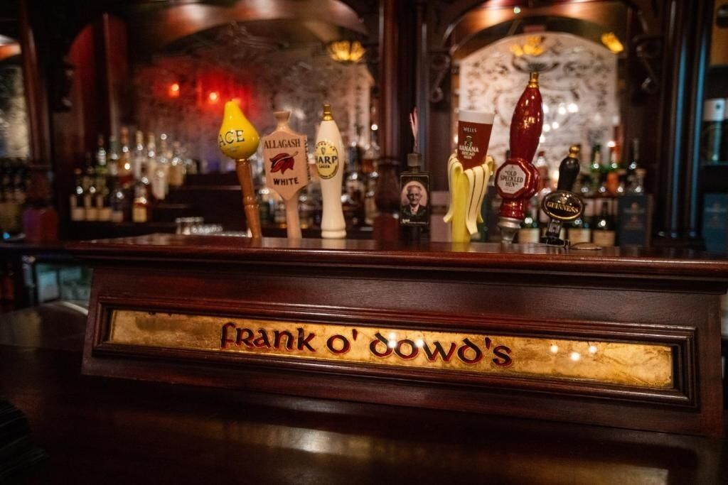 Un bancone bar con varie spine di birra e un cartello che recita "Frank O'Dowd's".