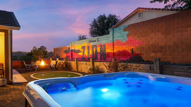 Un bain à remous avec une fresque représentant un coucher de soleil en arrière-plan.