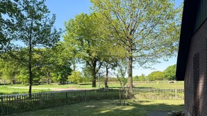A grassy area with trees and a brick wall. - 3 bedroom beautiful home in Gees (Gees)