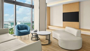 A modern living room with a sofa, armchair, and round coffee table.