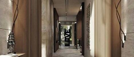 A corridor with wooden walls and a tiled floor, leading to a room with a bed and a window.