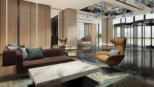 A modern lobby with a sofa, armchair, and marble coffee table.