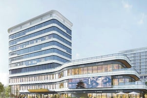 A modern multi-story building with a curved facade, large windows, and multiple logos indicating commercial spaces.