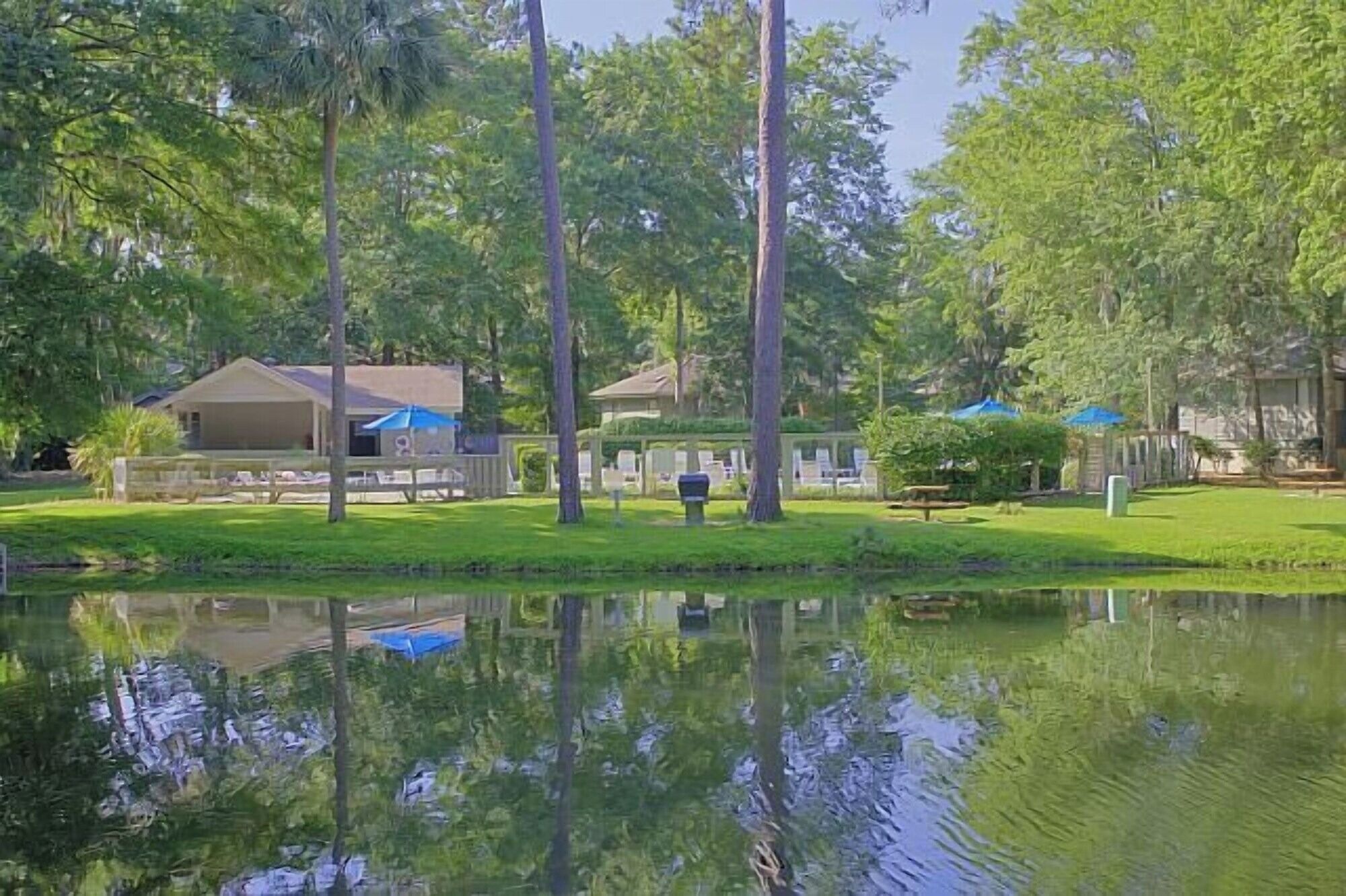 Un entorno tranquilo junto al lago con una casa, un porche cubierto y un pequeño muelle.