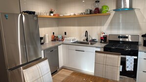 Eine moderne Küche mit Edelstahlgeräten, einer Holz Arbeitsplatte und einem eingebauten Backofen.