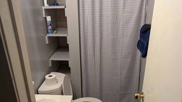 Een douche, handdoeken, zeep, toiletpapier