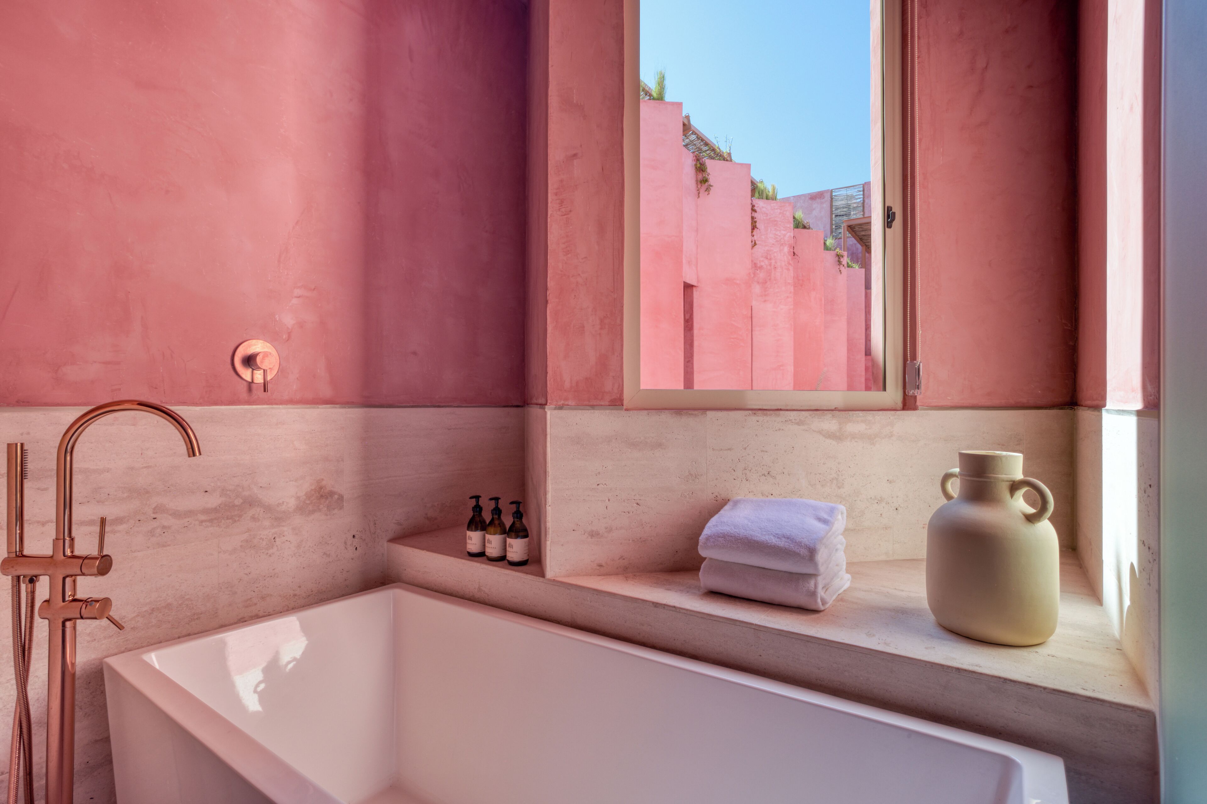 Une salle de bain moderne dotée d’une grande baignoire, d’une douche et d’une fenêtre offrant une vue sur l’extérieur.