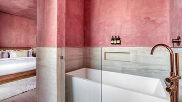 Uma casa de banho moderna com uma banheira grande, um chuveiro e uma toucador com lavatório.