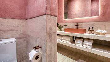 A bathroom with a toilet, a sink with a mirror, and a towel rack.