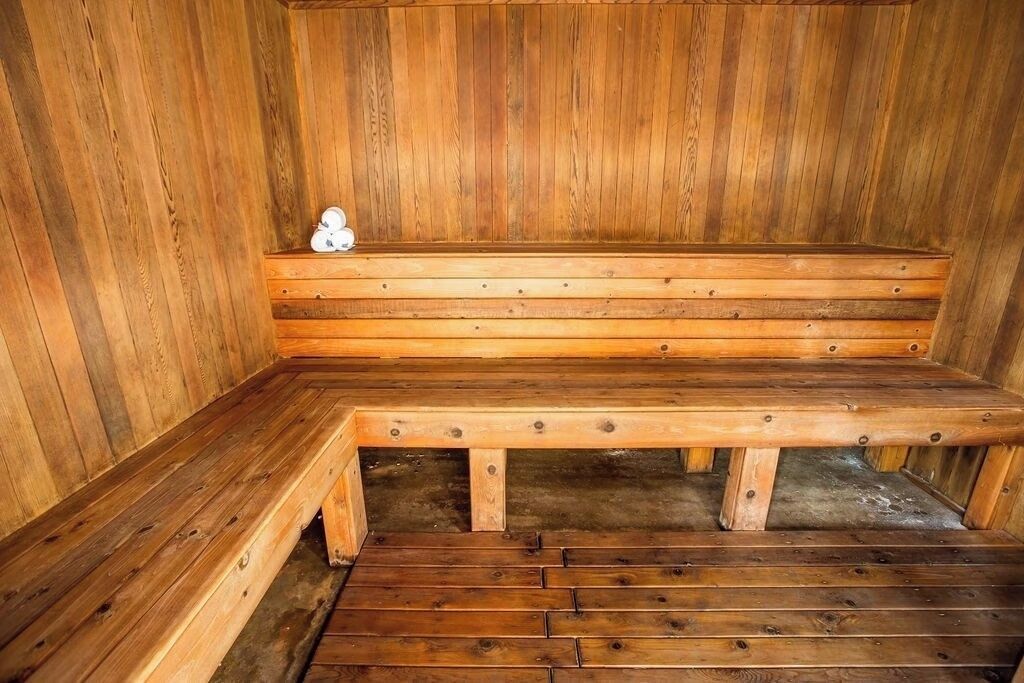 Eine Holzsauna mit Bänken, darunter eine Bank mit einem Handtuch.