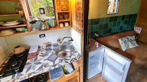 A compact kitchen with a gas stove, sink, and a small refrigerator. - La Casita Del Bosque, a mini-hut surrounded by native forest (Barichara)