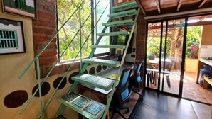 A staircase with a unique design, leading to an outdoor area with a dining table and chairs. - La Casita Del Bosque, a mini-hut surrounded by native forest (Barichara)
