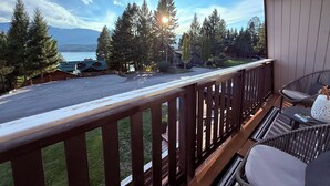 A wooden deck with a view of a lake and mountains, a chair, and a table. - Hilltop's Cozy Cabin with Lakeviews, close to beach. Pet friendly (Windermere)