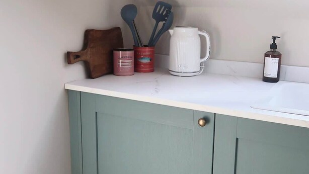 A kitchen with a white countertop, a teal cabinet, and various kitchen utensils. - Bright Coastal Retreat – Stunning Sea Views (Ards and North Down)