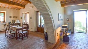 A spacious dining area with a wooden table and chairs, a staircase leading to an upper level, and a balcony with a view. - Amazing home in Lisciano Niccone (Lisciano Niccone)