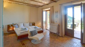A bedroom with a bed, a chair, a window, and a door leading to an outdoor area. - Amazing home in Lisciano Niccone (Lisciano Niccone)