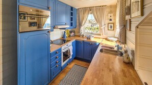 A compact kitchen with blue cabinets, a built-in oven, and a sink.