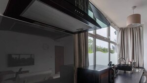 A modern kitchen with a built-in stove, a window with curtains, and a sink area. - Luxury modern flat • close to city • free parking (Leeds)