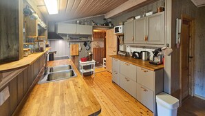 Eine kleine Küche mit Holzausziehtisch, Spüle und Mikrowelle.