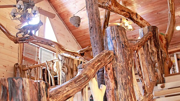 Eine Holztreppe mit einem besonderen Design, mit natürlichen Holzelementen und einem Deckenventilator.