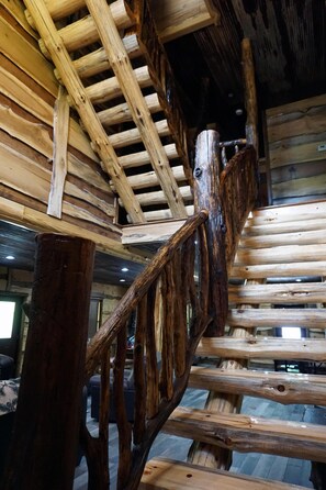 Eine hölzerne Wendeltreppe mit rustikalem Design, aus Baumstämmen und Balken.