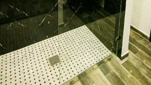 Ein modernes Badezimmer mit Duschkabine aus Glas, Waschbecken und Spiegel.