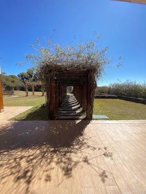 A wooden pergola with a pathway leading through it. - Hortênsia Boutique - Private Chalet 1 (Campos do Jordão)