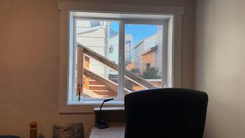 A room with a large window overlooking a staircase and buildings.