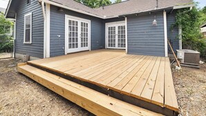 A house with a wooden deck, grey siding, and white-framed doors. - *Mins To Methodist Hospital* Lux & Cozy* (San Antonio)