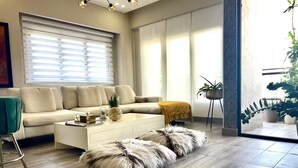 A modern living room with a beige sofa, a white coffee table, and a fluffy pouf. - NewExclusive Apartment Downtown, GYM, POOL&MORE 407 (Santo Domingo)