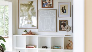 A living room with a sofa, a coffee table, and a white bookshelf with various items. - Lihau Boho House (Kailua-Kona)