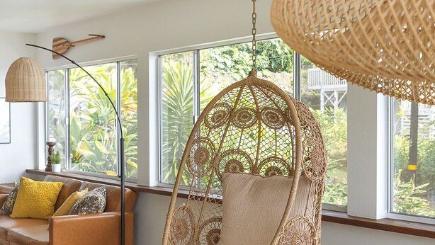 A modern living room with a hanging chair, a sofa, and a dining table. - Lihau Boho House (Kailua-Kona)