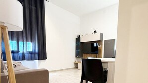 A modern, well-lit room with a desk, chair, and a sofa. - ⭐️ Luminis Holiday Home - Comfort and the sea at your fingertips ⭐️ (Porto Torres)