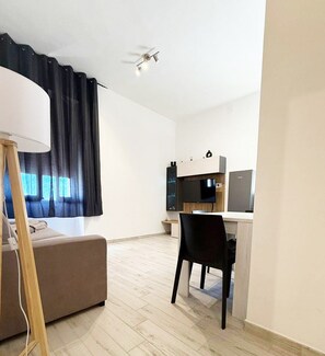 A modern, well-lit room with a desk, chair, and a sofa. - ⭐️ Luminis Holiday Home - Comfort and the sea at your fingertips ⭐️ (Porto Torres)