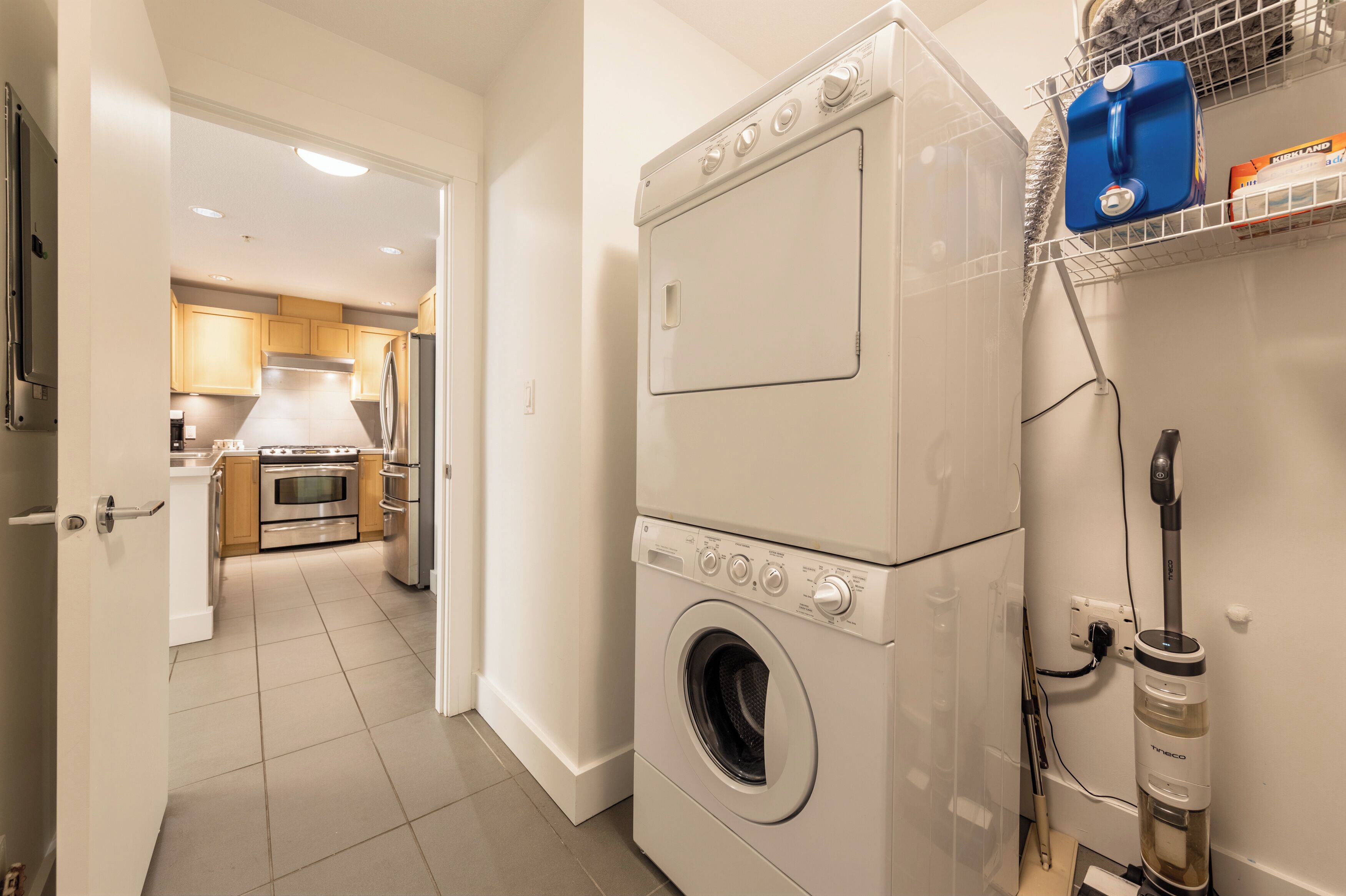A laundry area with a washing machine, a dryer, and a vacuum cleaner.