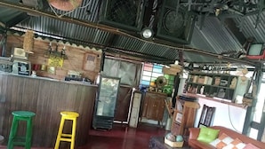 Ein rustikales Interieur mit Barbereich, Holzmöbeln und einem roten Boden.