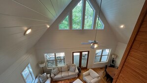 Ein geräumiges Loft mit hohen Decken, großen Fenstern und einem Deckenventilator.